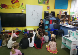 Dzieci rozmawiają na temat piosenki "Nasze przedszkole" i ilustracji na tablicy