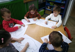 Dzieci rysują kredkami świecowymi ukośne kreski w rytmie piosenki "Jeż"