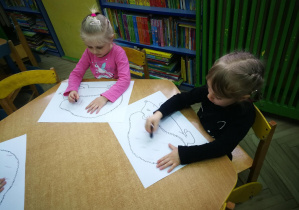 Lena i Nadia rysują kredkami świecowymi ukośne kreski w rytmie piosenki "Jeż"