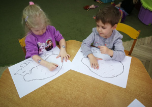 Hania i Filip rysują kredkami świecowymi ukośne kreski w rytmie piosenki "Jeż"