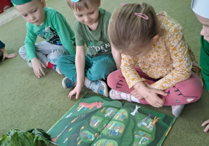 Dzieci przyglądają się przekrojowi kapusty na obrazku w książce