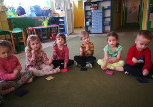 Dzieci wygrywają rytm piosenki "Termometr" piąstkami na woreczkach