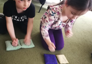 Dzieci piąstkami wygrywają na woreczkach rytm piosenki "Pajacyk"