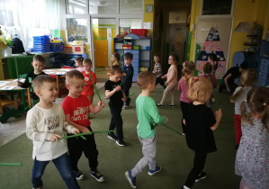 Dzieci poruszają się do piosenki "Pajacyk" i wygrywają rytm na patyczkach/pałeczkach