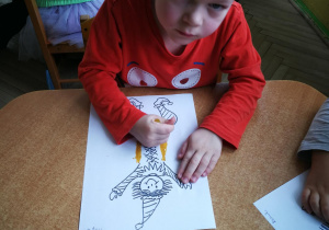 Filip rysuje kredką pastelową dwie pionowe linie do piosenki "Pajacyk"