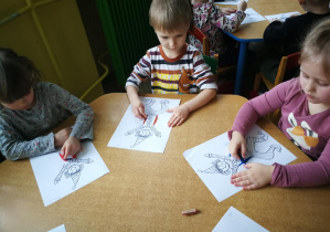 Michasia, Stasio i Oliwka rysują kredką pastelową dwie pionowe linie do piosenki "Pajacyk"