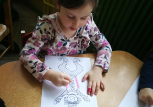 Hania rysuje kredką pastelową dwie pionowe linie do piosenki "Pajacyk"