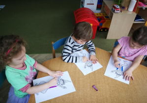 Laura, Olaf i Marysia rysują kredką pastelową dwie pionowe linie do piosenki "Pajacyk"