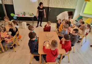 Dzieci podczas zajęć przy stolikach