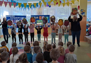 Dzieci śpiewają i przedstawiają za pomocą ilustracji owoców piosenkę o zdrowym odżywianiu