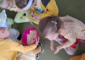 Michasia częstuje dzieci przyrządzonym na zajęciach popcornem