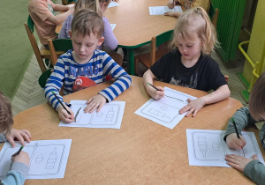Gabrysia, Gabryś, Mateusz i Leoś rysują ołówkiem na rysunkach poziome linie od lewej do prawej w rytmie piosenki "Zaczarowany ołówek"
