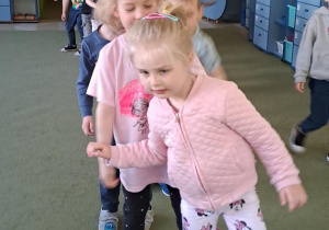 Dzieci biorą udział w zabawie ruchowo-słuchowej pt. „Skok przez drogę”