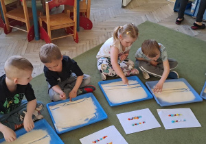 Dzieci rysują palcami na mannie wzór w rytmie piosenki "Droga"
