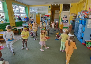 Dzieci ćwiczą równowagę i koordynację w zabawie ruchowej "Ziemniak na talerzu"