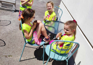 Dzieci siedzą przy stoliku i jedzą lody