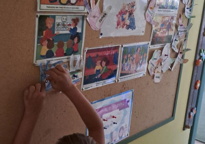 Olaf przyczepia papierową dłoń na tablicy z zasadami przedszkolnymi Puchatków