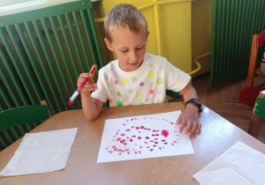 Janek maluje kropki za pomocą pędzla i farby