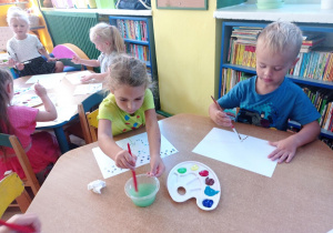 Tymek i Marysia malują kropki za pomocą pędzla i farby