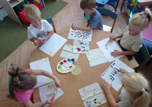 Dzieci tworzą kreatywne prace z kropek powstałych ze stęplowania po kartce pędzlem umoczonym w farbie
