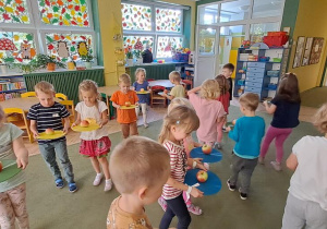 Dzieci ćwiczą równowagę podczas zabawy z wykorzystaniem jabłek