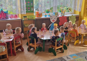 Dzieci jedzą słodki poczęstunek od Ignasia