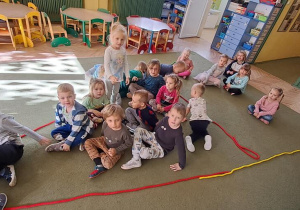 Dzieci siedzą w literce "A" ułożonej z liny