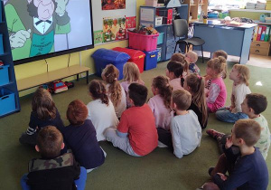 Dzieci oglądają film o Marii Skłodowskiej - Curie w gościnie u Puchatków.