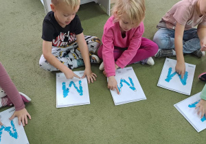 Dzieci uczą się poprawnie kreślić literę "M"