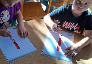 Marysia i Tymek rytmicznie malują litery "I" podczas piosenki "Iza"