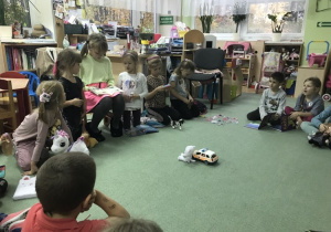 Milenka czyta, dzieci słuchają w kole na dywanie