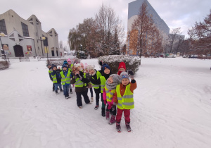 Uśmiechnięte dzieci podczas zimowego spaceru w okolicach przedszkola