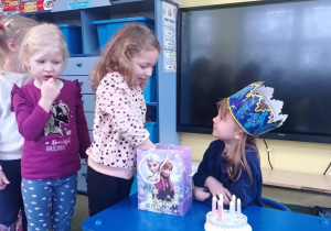 Laura częstuje się urodzinowym cukierkiem Misi