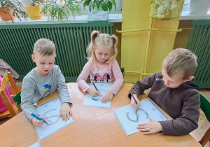 Antoś, Oliwka i Jaś rysują literę "S" na kartkach podczas piosenki "Sławek"