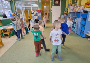 Dzieci poruszają się w rytmie piosenki "Natalia" przyklejone plecami w parach
