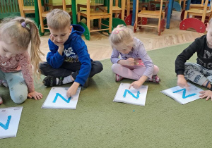 Pięciolatki odtwarzają litery "N" na wyklejonych wzorach w rytmie piosenki "Natalia"