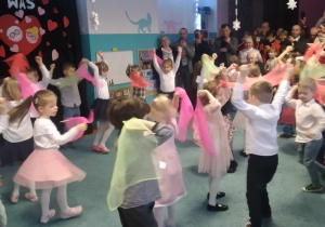 Dzieci z kolorowymi chustami prezentują taniec podczas przedstawienia