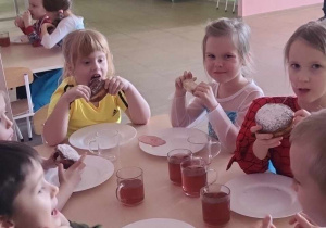 Dzieci podczas jedzenia pączków