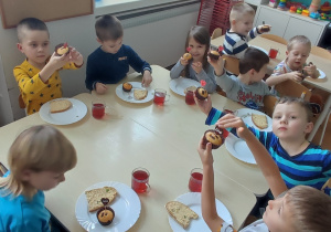 Dzieci siedzą przy stoliku, jedzą słodkie babeczki przygotowane przez mamę Aleksa