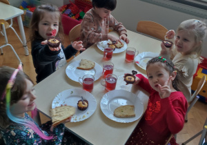 Dzieci siedzą przy stoliku, jedzą przepyszne, walentynkowe babeczki