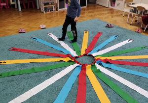 Tymofii utrwala rytmy z wykorzystaniem kolorowego wiatraka matematycznego rozłożonego na dywanie