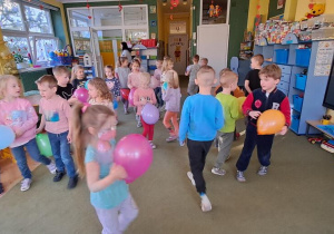 Dzieci uczestniczą w zabawie ruchowej „Z balonem”