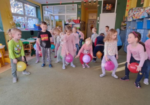 Dzieci z balonami między kolanami
