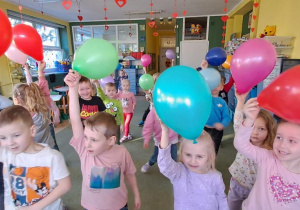 Dzieci trzymają balony w prawych dłoniach