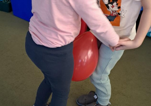 Hania i Antoś tańczą do piosenki "Bronisław", trzymając balon kolanami