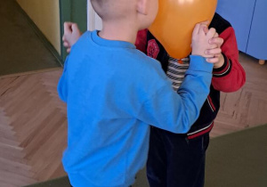 Leon i Gabryś tańczą do piosenki "Bronisław", trzymając balon głowami