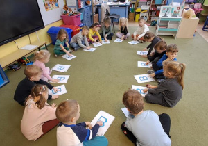 Dzieci rysują palcami na wyklejonych wzorach litery "B" w rytmie piosenki "Bronisław"