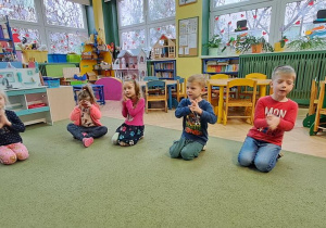 Dzieci rytmicznie poruszają dłońmi do piosenki "A ram zam zam"