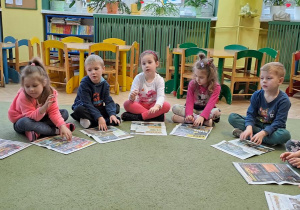 Dzieci wygrywają na gazetach rytm piosenki "Grzegorz"