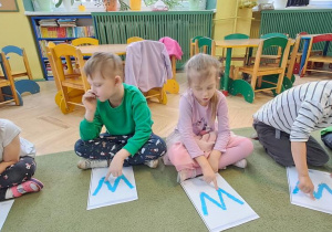 Marysia, Leon, Klara, Olaf i Jaś kreślą palcami litery "W" na wyklejonych wzorach w rytmie piosenki "Weronika"